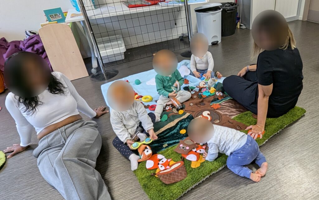 eveil et douceur enfants qui jouent sur tapis d'éveil avec leur assistante maternelle